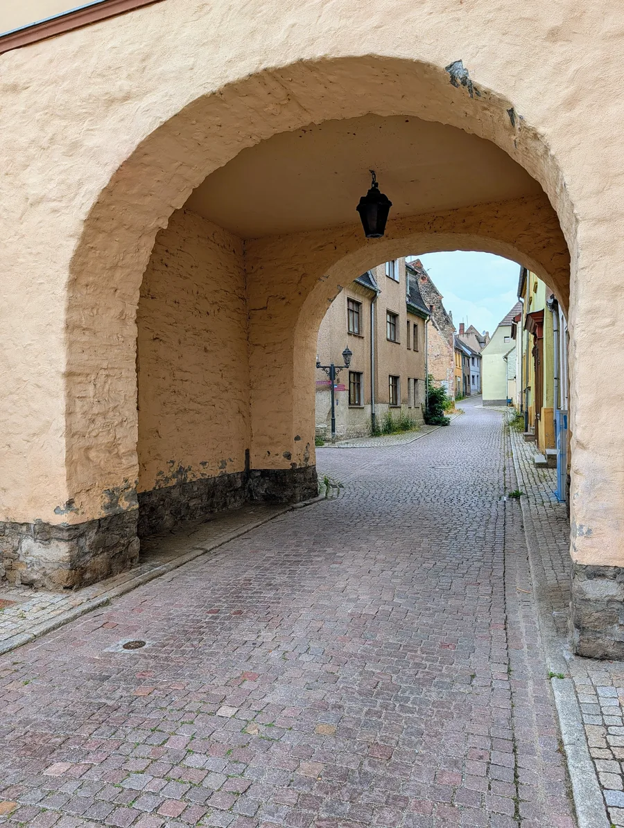 Blick durch einen Torbogen in eine Gasse der Altstadt von Alsleben